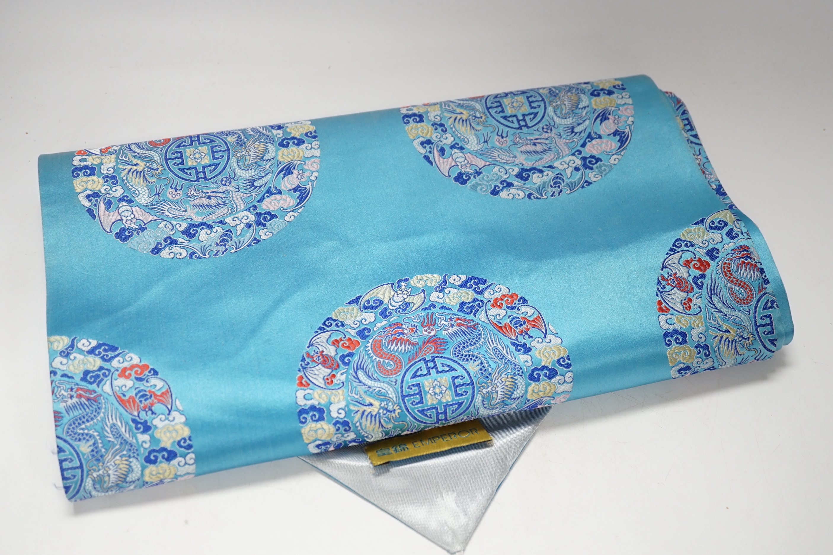 A 20th century Chinese hanging scroll watercolour on silk, two cranes on a pine tree, with brocade border, together with a blue Chinese silk table runner with brocade mon decoration